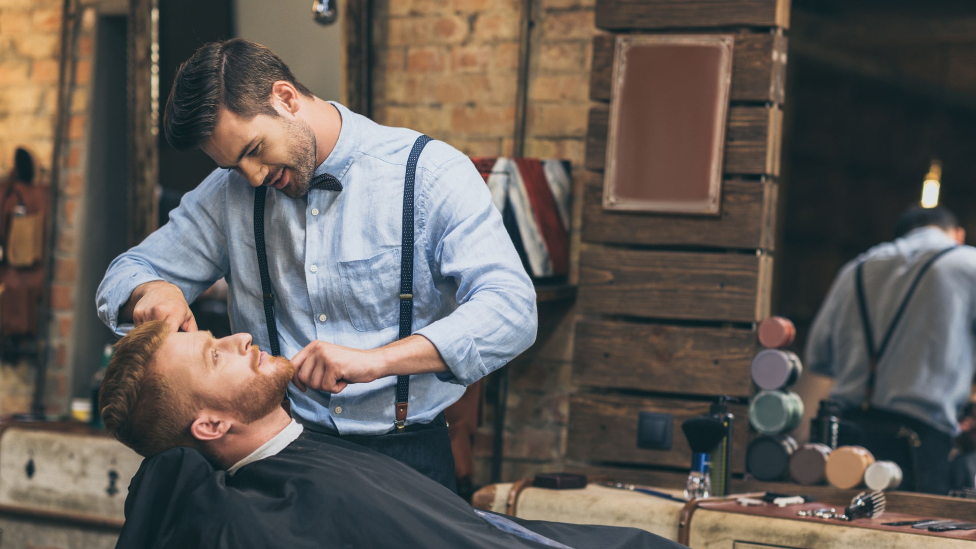 barber doing a haircut and beard trimming to a client
